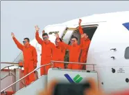  ?? FANG ZHE / XINHUA ?? Crew members of the C919, China’s first homegrown large passenger plane, wave at spectators in Shanghai on Friday after the plane completed its first test flight.