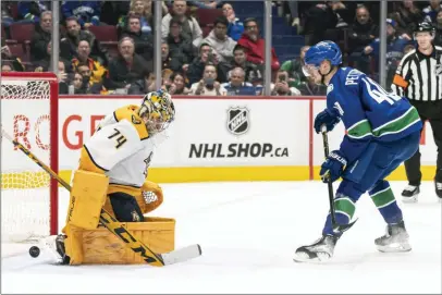  ?? ?? The Canadian Press
Vancouver Canucks’ Elias Pettersson (right) scores on Nashville Predators goalie Juuse Saros during the shootout in NHL hockey action in Vancouver, Monday. The Canucks defeated the Predators 4-3.