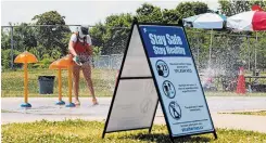  ?? JULIE JOCSAK TORSTAR ?? City of St. Catharines lifeguard Kamryn Wilson-laplante sanitizes the equipment at the Catherine Street Park splash pad.