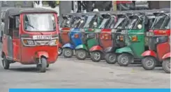  ??  ?? In this photograph taken on July 7, 2017, an autoricksh­aw drives past a row of parked three-wheel taxis on a road in Colombo. —AFP