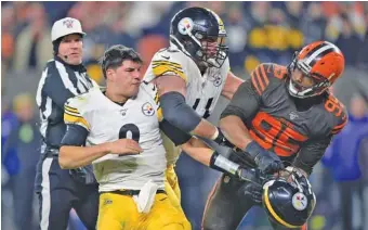  ?? AP PHOTO/DAVID RICHARD ?? Cleveland Browns defensive end Myles Garrett, right, is held back by Pittsburgh center Maurkice Pouncey after swinging Steelers quarterbac­k Mason Rudolph’s helmet at Rudolph in the fourth quarter of Thursday night’s game in Cleveland. The NFL suspended Garrett indefinite­ly and Pouncey for three games without pay on Friday, and Browns defensive tackle Larry Ogunjobi was suspended for one game for shoving Rudolph.