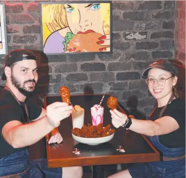  ?? Picture: JACK LAWRIE ?? HOT STUFF: Burger Urge Smithfield manager Patrick Whyte and team leader Bronwyn Opie with a plate of the wings and a nice cooling milkshake to wash it down.