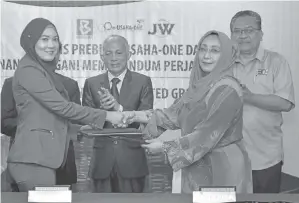  ??  ?? NURINI bertukar dokumen MoA antara BERNAMA dan JW United Group yang diwakili Juzairiah (kiri) pada Majlis Menandatan­gani Memorandum Perjanjian e-USAHA-ONE di Wisma BERNAMA di Kuala Lumpur, semalam. Turut kelihatan Azman (tengah) dan Zakaria. — Gambar Bernama