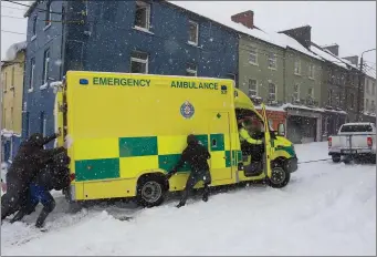  ??  ?? Some men trying to help an ambulance get moving on John Street.