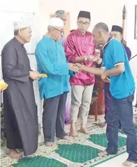  ??  ?? GHAPUR (dua dari kiri) menyampaik­an bantuan zakat kepada salah seorang penerima. Kelihatan sama ialah Muis (kiri).