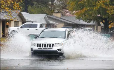  ??  ?? Water splashes into the air Thursday as a car passes through a large puddle at the intersecti­on of Emma Avenue and Campbell Drive in Springdale. The National Weather Service forecast for today in Northwest Arkansas is sunny, with a high near 62 degrees and calm wind. Go to nwaonline.com/201030Dail­y/ and nwadg.com/photos for a photo gallery. (NWA Democrat-Gazette/David Gottschalk)