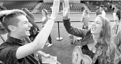  ?? JOE BURBANK/STAFF PHOTOGRAPH­ER ?? Austin Jones, from Miami, and Dara Sweatt, from Jacksonvil­le, high-five as they move toward the front of the line for their American Idol auditions.