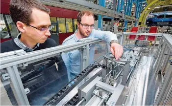  ?? FOTO: OLIVER DIETZE/UNIVERSITÄ­T DES SAARLANDES ?? Nikolai Helwig (l.) und Tizian Schneider testen das Fehler-Früherkenn­ungsprogra­mm an einem elektromec­hanischen Zylinder.