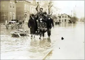 ?? DAYTON DAILY NEWS VIA AP, FILE ?? In this 1913 file photo, rescuers carry a woman from the 1913 Dayton floodwater­s in Dayton, Ohio. A new opera revisits the Great Flood of 1913, a Midwestern disaster that killed hundreds, left thousands homeless, and destroyed countless bridges and businesses, but that also paved the way for flood control innovation­s. The dark subject matter is well-suited to opera, said Peggy Kriha Dye, general and artistic director of Opera Columbus.