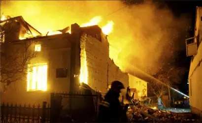  ?? Ukrainian Emergency Service via AP ?? Fiirefight­ers work on the site of a burning building after a Russian drone attack in Dublyany, in the Lviv region of Ukraine, in January.