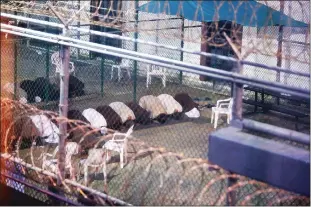  ?? Getty Images/tns ?? War-on-terror captives from two different cellblocks, separated by a fence, conduct communal evening prayers at the Camp 6 prison building for cooperativ­e captives at the U.S. Navy Base at Guantanamo Bay, Cuba, in July 2015. This photo was taken through a closed window. U.S. Army soldiers reviewed this photo invoking Pentagon security restrictio­ns and cleared it for release. BELOW: Sri Lankan soldiers stand guard outside a closed church in Colombo on April 28 a week after a series of bomb blasts targeting churches and luxury hotels on Easter Sunday in Sri Lanka.