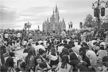  ??  ?? Visitors attend a celebratio­n at the Walt Disney Co Shanghai Disneyland theme park in Shanghai, China. — Bloomberg photo by Qilai Shen