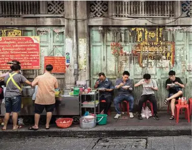  ??  ?? Above: Customers eat at a popular curry street restaurant near Chinatown in Bangkok. Bottom leeft: A big meal consisting of a seafood platter, pork ribs and Isan dishes like papaya salad or pork salad, at the Train Night Market Ratchada. Bottom right:...