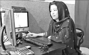  ??  ?? Hameeda Ali Hazara, who is from the Shiite ethnic minority Hazara community and runs the “Hazara” restaurant, works on a computer at the eatery in Hazara Town, a neighbourh­ood in Quetta. — AFP photos