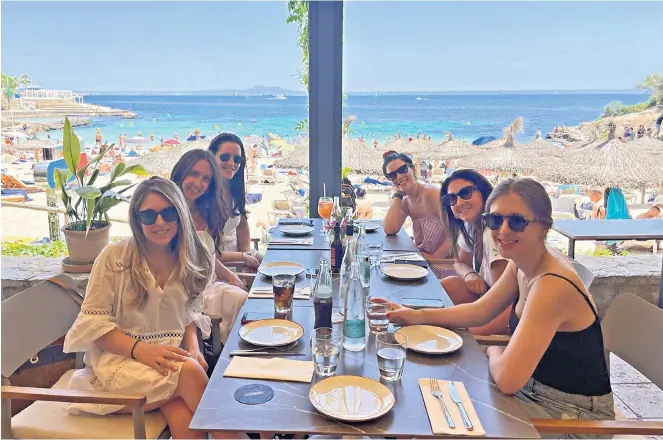  ?? ?? g Friends reunited:
Kari (second from right) and her group enjoy some child-free al-fresco dining on the beach