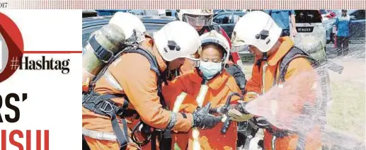  ?? IZHARI ARIFFIN
PIC BY ?? Sabah Fire and Rescue Department personnel helping Mohammad Faisul Iman to handle a hose reel in the compound of Women and Children Hospital in Kota Kinabalu yesterday.