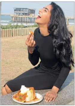  ?? PICTURE: ZAIL SINGH ?? Mumtaaz Sophia Khan, 23, a final year law student and Durban model at Models Internatio­nal, tucks into a Gounden’s mutton bunny chow at uShaka Beach yesterday, after Durban was named the coolest city in South Africa by CNN Travel.