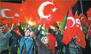  ?? OSMAN ORSAL / REUTERS ?? Supporters of Turkish President Tayyip Erdogan celebrate at the ruling Justice and Developmen­t Party’s headquarte­rs in Izmir, Turkey, on Sunday.