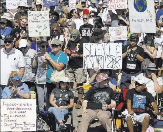  ?? Christian K. Lee Las Vegas Review-Journal @chrisklee_jpeg ?? Followers of a March for Science rally wave signs — some politicall­y themed — Saturday at the Art Square parking lot.