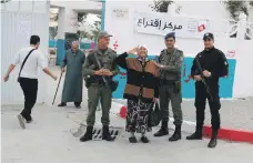  ?? Reuters ?? A voter poses with soldiers and a policeman at a polling station for the municipal election in Tunis yesterday