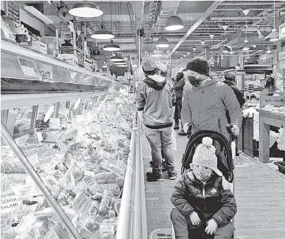  ?? HANNA BEIER/REUTERS ?? En medio de la pandemia, clientes compran en Reading Terminal Market.