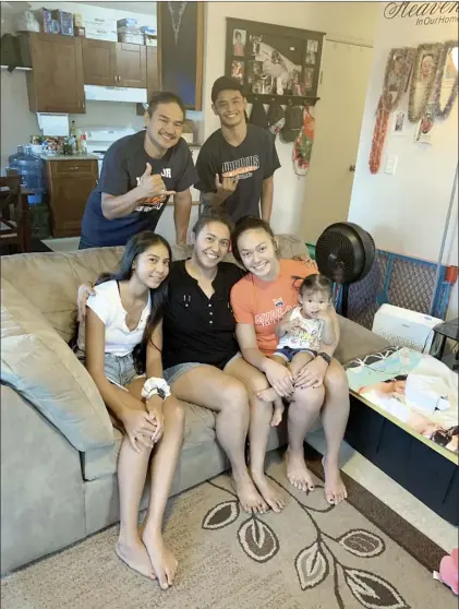  ?? The Maui News / ROBERT COLLIAS photo ?? The Hayase ohana — Jason Hayase (top, from left), Leland Hayase, Alexis Peligrino-Hayase (bottom, from left), Jonelle Hayase, Tayler Peligrino-Hayase and Quinn Hayase, 1 — pose for a photo in their Lahaina apartment Monday. Jonelle was diagnosed with stage 4 colon cancer in May, and while doctors say she has just a few years to live, she and husband Jason are focused on raising Quinn while Tayler — at her parents’ encouragem­ent — attends and wrestles for Midland University in Fremont, Neb.