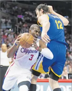  ?? Danny Moloshok Associated Press ?? CHRIS PAUL , who scored 27 points, drives around Golden State center Andrew Bogut during the first half at Staples Center.