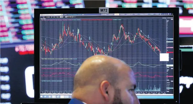  ?? RICHARD DREW/ AP PHOTO, FILE ?? Photo specialist John Parisi works at his post at the New York Stock Exchange. A period of relative calm on Wall Street that led to a milestone-setting September for the stock market came to a sudden, screeching halt in October. The slide snapped a six-month winning streak for the S&amp;P 500.