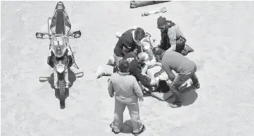  ??  ?? British biker Sam Sunderland is assisted by medical staff after a crash during Stage 4 of the Dakar 2018, in and around San Juan De Marcona, Peru. — AFP photo