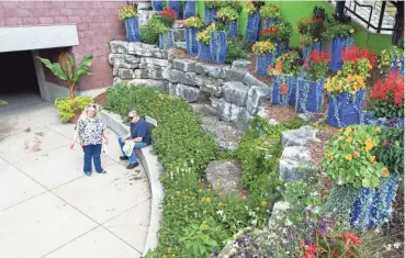  ?? CHRIS KOHLEY/MILWAUKEE JOURNAL SENTINEL ?? Flowers are planted in blue milk crates, chicken boxes and old light fixtures.