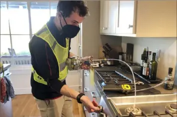  ?? Rob Jackson/Associated Press ?? Researcher Eric Lebel samples natural gas from a stove in Stanford, Calif., in 2021. Gas stoves are worse for the climate than previously thought because of constant tiny methane leaks even while they’re off.