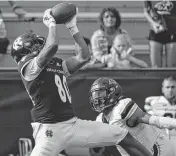  ?? ALAN ARSENAULT USA TODAY NETWORK ?? Holy Cross’s Jalen Coker hauls in a pass for a first down over Merrimack’s Darion McKenzie in 2023.