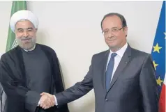  ?? AFP ?? France’s President Francois Hollande, right, shakes hands with Iran’s President Hassan Rohani on Tuesday at the UN Headquarte­rs in New York