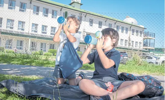  ?? ALEJANDRO GUYOT ?? El mediodía es la hora crítica: muchas madres, como Carla Mora, improvisan un picnic para sus hijos cerca del colegio