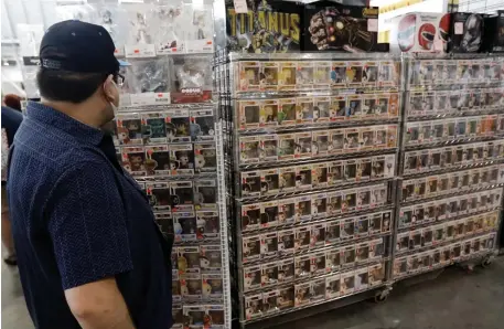  ??  ?? SHORT FORM: An expo attendee checks out a display of Marvel Avengers ‘Pop!’ figurines.