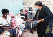  ?? ?? First Lady Dr Auxilia Mnangagwa hands over sunscreen lotion to Tanyaradzw­a Mugeyi during her visit in Mabvuku yesterday