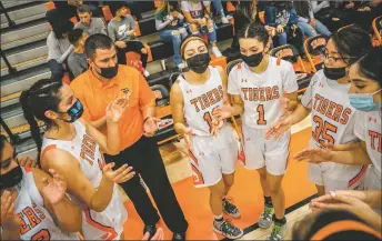  ?? NATHAN BURTON/Taos News ?? The Lady Tigers head coach Eric Mares discusses strategy with his players during a home game on Tuesday (Jan. 11).