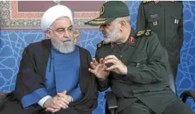  ?? —AP ?? LOOMING STORM Iranian President Hassan Rouhani (left) listens to Maj. Gen. Hossein Salami of the Iranian Islamic Revolution­ary Guard Corps at a military parade outside Tehran on Sunday.