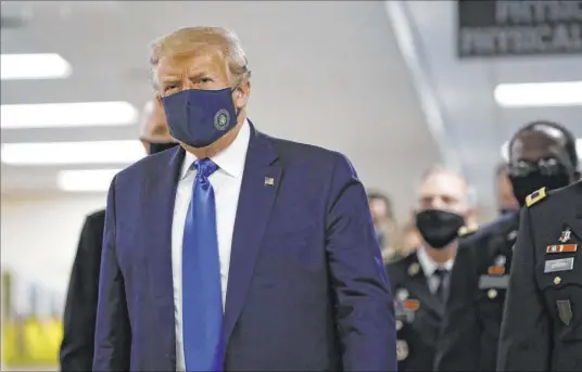  ?? Patrick Semansky The Associated Press ?? President Donald Trump wears a mask Saturday for a visit to Walter Reed National Military Medical Center in Bethesda, Md.