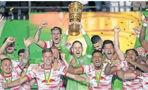  ?? FOTO: MICHAEL SOHN/AP ?? Leipzigs Spieler feiern den Sieg im DFB-Pokal. Torhüter und RB-Kapitän Peter Gulasci hebt die Trophäe hoch.