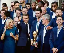  ?? Francois Mori/AFP ?? O presidente francês Emmanuel Macron recebe a seleção francesa em Paris com a taça da Copa