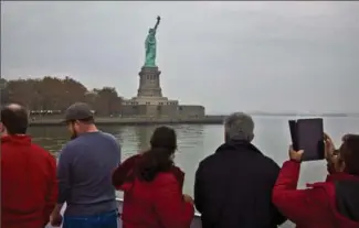  ?? ASSOCIATED PRESS FILE PHOTO ?? Visitors view the Statue of Liberty during a ferry ride. The head of New York City’s tourism organizati­on says he’s keen “to counter a little bit of the negative rhetoric that is coming out of Washington.”