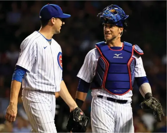  ?? JUSTIN CASTERLINE/GETTY IMAGES ?? Veterans Kyle Hendricks (left) and Yan Gomes see the Cubs’ emphasis on unity and familiarit­y as the secret to greater on-field success this season.