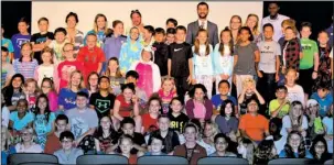  ?? Submitted photo ?? COME TOGETHER: Fifth-grade students from Lakeside Middle School gathered with alumni Natalie Larrison and Mouaz Moustafa, from the Syrian Emergency Task Force, on the high school auditorium stage May 25 following their presentati­on about their advocacy...