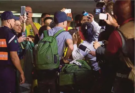  ?? AFP PIC ?? Brazil player Philippe Coutinho (centre) is greeted by fans on his arrival in Rio de Janeiro on Sunday.
