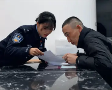  ?? ?? A police officer answers questions about a hukou (household registrati­on) at a border police station in Hemu Village, Altay, Xinjiang, on March 8