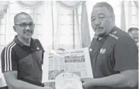  ??  ?? AHMAD Yussof (kiri) menyampaik­an cenderamat­a kepada Zul Othman, ketua jurulatih bola sepak senior PSKPPS Sandakan.