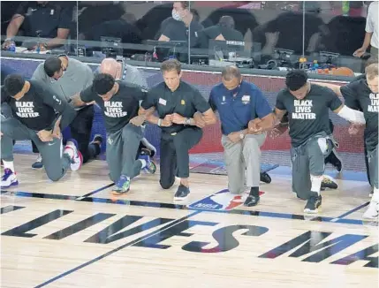  ?? CHARLES KING/ORLANDO SENTINEL ?? Players and coaches kneel during the national anthem before the Jazz played the Pelicans in the HP Field House at ESPN Wide World of Sports Thursday. It was the first game of the NBA restart.