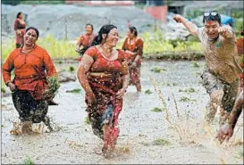  ?? NIRANJAN SHRESTHA/AP ?? Farmers frolic in Lele, Nepal, on Friday to celebrate the first day of planting rice for the season. The national holiday features singing, dancing and playing in muddy fields.