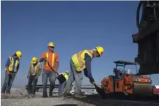  ?? MARCUS OLENIUK/TORONTO STAR ?? Highway workers pave the 407 East extension in north Pickering.